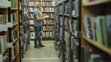 一个年轻人在图书馆里选一本书。 书多，他就在书串之间的走廊里..